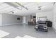Large three-car garage featuring epoxy flooring, a dart board, a golf cart, and bar seating at 1606 Cedar Valley Dr, Port Charlotte, FL 33953