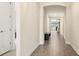 Long, bright hallway featuring tile flooring, arched doorway, and view to the outside through living room at 1606 Cedar Valley Dr, Port Charlotte, FL 33953