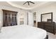 Spacious main bedroom featuring a tray ceiling, large closet, dresser, and ensuite bathroom at 1606 Cedar Valley Dr, Port Charlotte, FL 33953