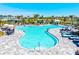 A stunning turquoise pool surrounded by lounge chairs and palm trees on a sunny day at 1606 Cedar Valley Dr, Port Charlotte, FL 33953
