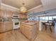 Bright, updated kitchen with a kitchen island, granite counters, stainless appliances, and hardwood flooring at 1750 Jamaica Way # 322, Punta Gorda, FL 33950
