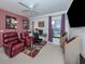 Comfortable living room area with a computer, television, recliner chairs, and natural lighting at 1750 Jamaica Way # 322, Punta Gorda, FL 33950