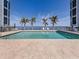 Beautiful pool with lounge chairs, palm trees and ocean views beyond the fence at 1750 Jamaica Way # 322, Punta Gorda, FL 33950