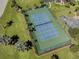 Aerial shot of a meticulously maintained tennis court, surrounded by lush landscaping and healthy green grass at 1750 Jamaica Way # 322, Punta Gorda, FL 33950