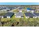 Aerial view of a new home construction development, with a pond and manicured green lawns at 1766 Sunset Preserve Way, Port Charlotte, FL 33953