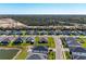 An aerial view of a new home construction development with various houses and a distant treeline at 1766 Sunset Preserve Way, Port Charlotte, FL 33953