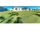 An image of a green backyard with neighboring homes and clear skies at 1766 Sunset Preserve Way, Port Charlotte, FL 33953