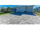 A gray brick driveway leads to a home with a two-car garage and manicured front yard at 1766 Sunset Preserve Way, Port Charlotte, FL 33953