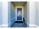 Welcoming entryway featuring a blue front door with a black welcome mat and gray brick flooring at 1766 Sunset Preserve Way, Port Charlotte, FL 33953