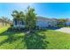 Well-maintained front yard with lush green grass, plants and trees, and a gray brick driveway at 1766 Sunset Preserve Way, Port Charlotte, FL 33953