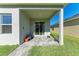 A covered patio with gray pavers and landscaping and a sliding glass door at 1766 Sunset Preserve Way, Port Charlotte, FL 33953