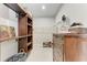 This walk-in closet features custom wood shelves and a convenient built-in ironing board at 1766 Sunset Preserve Way, Port Charlotte, FL 33953