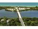 Overhead aerial view of a bridge spanning a river, with lush greenery and beaches in the background at 1769 Manasota Beach Rd, Englewood, FL 34223