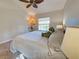 Comfortable bedroom with a leaf-shaped ceiling fan, a large window, and a cozy bed, creating a peaceful retreat at 1769 Manasota Beach Rd, Englewood, FL 34223