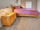 Cozy bedroom featuring soft carpet, a comfortable bed, a wooden nightstand, and natural lighting at 1769 Manasota Beach Rd, Englewood, FL 34223