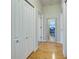 Hallway with hardwood floors and multiple storage closets, plus a decorative mirror that expands the space at 1769 Manasota Beach Rd, Englewood, FL 34223