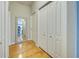 Hallway with hardwood floors, closet, decorative mirror, and fresh paint; a welcoming transition between rooms at 1769 Manasota Beach Rd, Englewood, FL 34223