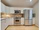 Bright kitchen with white cabinets, granite countertops, and stainless steel appliances at 1769 Manasota Beach Rd, Englewood, FL 34223
