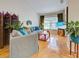Bright living room featuring hardwood floors, comfortable gray sofas, and natural light from a large window at 1769 Manasota Beach Rd, Englewood, FL 34223