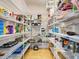 Walk-in pantry with floor-to-ceiling white metal racks, holding various food items and small appliances at 1769 Manasota Beach Rd, Englewood, FL 34223