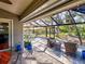 Relaxing screened-in patio featuring beautiful stone flooring, comfortable seating, and views of the lush yard at 1769 Manasota Beach Rd, Englewood, FL 34223