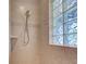 Elegant walk-in shower featuring tiled walls and glass block window at 1769 Manasota Beach Rd, Englewood, FL 34223