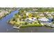 Aerial view of a waterfront property featuring a private pool, dock, and lush landscaping on a scenic canal at 18382 Arapahoe Cir, Port Charlotte, FL 33948