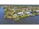Aerial view of beautiful waterfront home with dock, pool, and lush landscaping at 18382 Arapahoe Cir, Port Charlotte, FL 33948