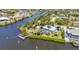 Aerial view of home on a canal with private boat dock and lush, mature landscaping at 18382 Arapahoe Cir, Port Charlotte, FL 33948