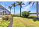Expansive backyard with lush green grass, mature palm trees, and beautiful views of the waterfront at 18382 Arapahoe Cir, Port Charlotte, FL 33948