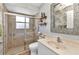 Bathroom featuring a tiled shower, updated vanity, and decorative mirror with lighting at 18382 Arapahoe Cir, Port Charlotte, FL 33948