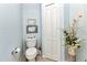 Powder room with neutral tiling, modern toilet, and blue accent wall at 18382 Arapahoe Cir, Port Charlotte, FL 33948