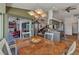 Open dining area with a wooden table, modern light fixture, and view of lanai and kitchen at 18382 Arapahoe Cir, Port Charlotte, FL 33948