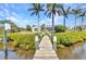 Picturesque waterfront home featuring a private dock surrounded by lush greenery and palm trees at 18382 Arapahoe Cir, Port Charlotte, FL 33948