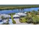 Waterfront home featuring a private dock, two-car garage, and lush landscaping at 18382 Arapahoe Cir, Port Charlotte, FL 33948