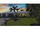Stunning single-story home featuring a metal roof, well manicured lawn and lush tropical landscaping at 18382 Arapahoe Cir, Port Charlotte, FL 33948