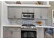 Close-up of kitchen featuring stainless steel microwave, oven, and grey subway tile backsplash at 18382 Arapahoe Cir, Port Charlotte, FL 33948