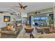 Spacious living room with high ceilings, neutral paint, ceiling fan, and a sliding glass door to the lanai at 18382 Arapahoe Cir, Port Charlotte, FL 33948