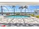 Screened pool with view of waterway surrounded by manicured landscaping and patterned pavers at 18382 Arapahoe Cir, Port Charlotte, FL 33948