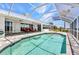 View of the pool and covered patio that has two chairs and views of the waterfront at 18382 Arapahoe Cir, Port Charlotte, FL 33948