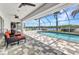 A screened in pool with a view of the water and seating area with ceiling fans on the screened in patio at 18382 Arapahoe Cir, Port Charlotte, FL 33948