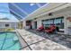 View of the covered patio with a well-maintained pool, outside kitchen, and outdoor seating at 18382 Arapahoe Cir, Port Charlotte, FL 33948