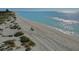 An aerial view of a pristine beach with clear blue water, white sand, and sparse vegetation at 1903 San Silvestro Dr, Venice, FL 34285