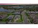 This aerial shot shows the house, landscaping, and surrounding community near a picturesque lake at 19800 Montenero Way, Venice, FL 34293