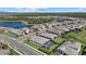 Scenic aerial view of homes in a community featuring lush landscaping, a lake, and manicured lawns at 19800 Montenero Way, Venice, FL 34293
