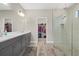 Elegant bathroom with double vanity, walk-in shower, and a peek into the walk-in closet at 19800 Montenero Way, Venice, FL 34293