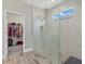 Modern bathroom with a clear glass shower, rainfall shower head, and window letting in natural light at 19800 Montenero Way, Venice, FL 34293