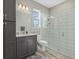 This bathroom features a tiled shower, wood-look floors, and a gray vanity for a modern and stylish design at 19800 Montenero Way, Venice, FL 34293