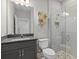 Bathroom featuring a walk-in shower with pebble flooring and a vanity with a dark countertop at 19800 Montenero Way, Venice, FL 34293