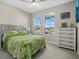 Bright bedroom with large windows, a decorative headboard, and coordinating dresser at 19800 Montenero Way, Venice, FL 34293